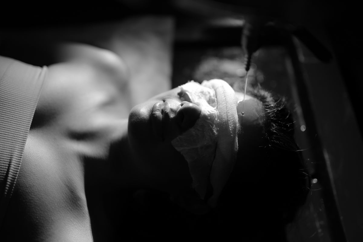 A person washing their face with a cloth.