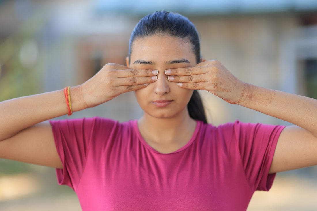 Young woman covering her eyes with hands