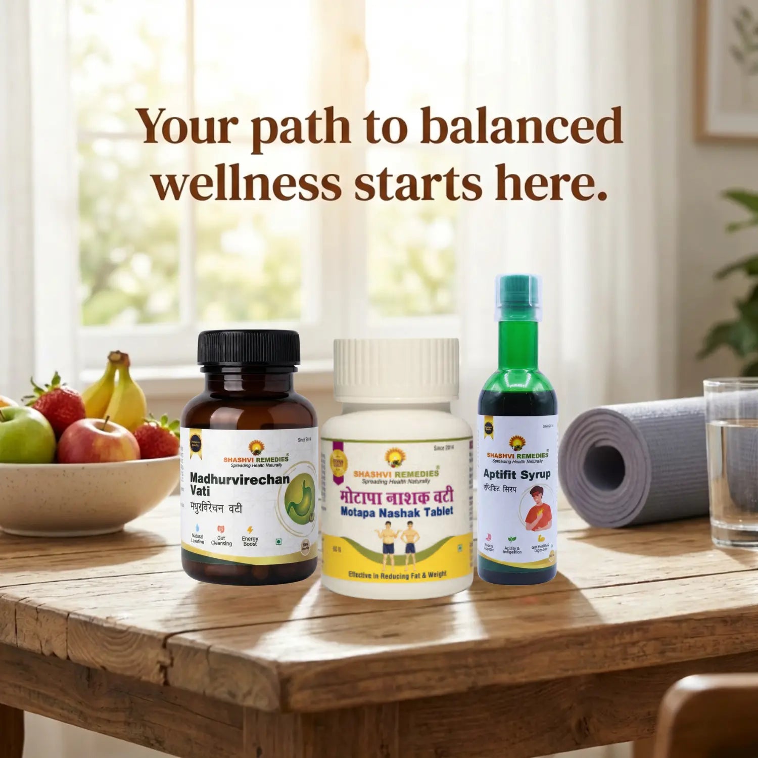 Three bottles of shashvi aptifit syurp, motapanashak vati Madhurvirechan products on a wooden table with fruits and a glass of water, with the text 'Your path to balanced wellness starts here.'.